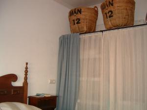a bedroom with a bed with baskets on top of a curtain at Casa Anavicente ON the beach in Calnegre