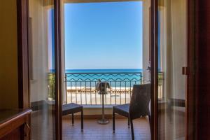 Habitación con balcón con vistas al océano. en Hotel Riva Del Sole en Cefalù