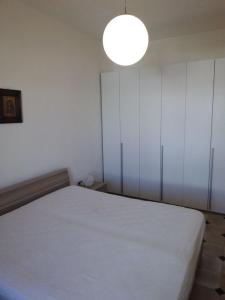 トッレ・デル・オルソにあるTorre Di Omeroのベッドルーム(白いベッド1台、ランプ付)