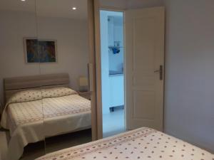 ラ・クロワ・ヴァルメにあるGolfe de Saint Tropez Terrasses de Sylvabelle Gigaroのベッド2台と鏡付きのベッドルーム1室