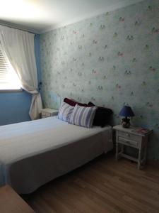 バレンシアにあるApartamentoの花の壁紙のベッドルーム1室(ベッド1台付)
