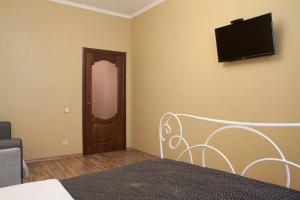 1 dormitorio con 1 cama y TV en la pared en Apartment Roksolana, en Leópolis