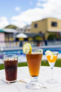 two drinks on a table next to a pool at El Cano in Guaillabamba