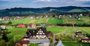 an aerial view of a small village in a green field at U Bizioma in Murzasichle