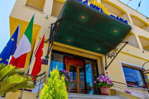 a building with flags on the front of it at Hotel Riva Del Sole in Cefalù