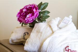 a purple flower in a towel next to a flower at Hotel Riva Del Sole in Cefalù