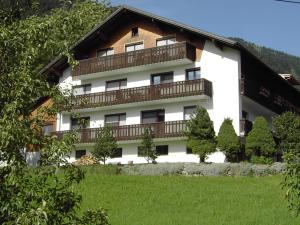 Großes weißes Gebäude mit Balkon in der Unterkunft Appartements am Stein in Bezau