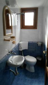 a bathroom with a toilet and a sink and a mirror at Guest House Raffe in Dobrinishte