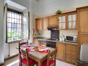 a kitchen with a table and chairs and a kitchen with a stove at Oltre le Mura in Rome