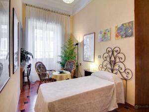 1 dormitorio con 1 cama, mesa y sillas en Oltre le Mura, en Roma