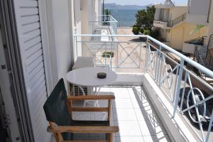 uma varanda com uma mesa branca e 2 cadeiras em Miloi Rooms and Apartments em Míloi