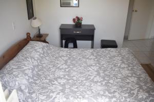 a bed in a bedroom with a table and a bedspread at Miloi Rooms and Apartments in Myloi