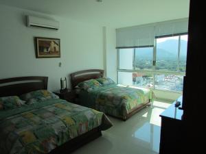 a bedroom with two beds and a large window at Costa Azul Suites 1002 in Papare