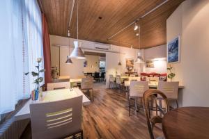 a dining room with wooden ceilings and tables and chairs at Hotel Derby Interlaken - Action & Relax Hub in Interlaken