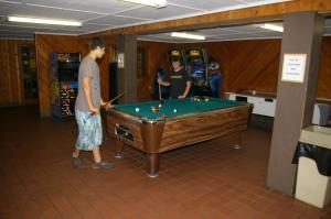 two men playing a game of pool in a room at Green Mountain Park in Lenoir