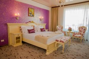 a bedroom with a large bed and purple walls at Almar Luxury in Mamaia Sat/Năvodari