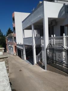 a white building with a balcony on a street at Guesthouse Ada in Bar