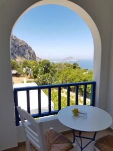 a room with a table and a view of the ocean at Amaranto Rooms in Aegiali