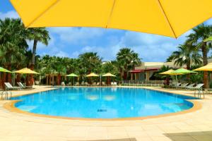 a large swimming pool with a yellow umbrella at The Ksar Djerba Charming Hotel & SPA in Midoun