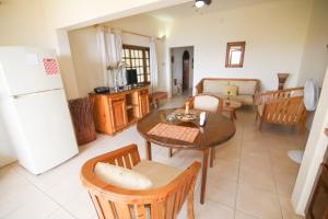 a kitchen and living room with a table and a refrigerator at Catcha Falling Star in Negril