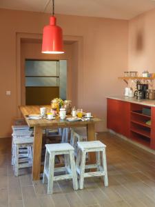 a kitchen with a wooden table and two stools at Back to Lisbon Hostel in Lisbon