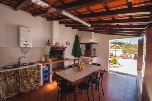 a kitchen with a wooden table and a wooden ceiling at Rivers Nation Surf Camp in Atouguia da Baleia