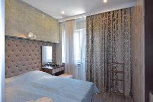 une chambre avec un lit bleu et une fenêtre dans l'établissement Pushkin 49, à Erevan