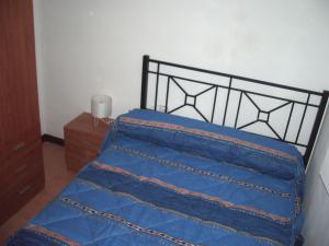 FayónにあるCasa Manzanaのベッドルーム(青いベッド1台、黒いヘッドボード付)