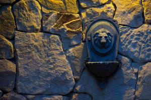 a stone wall with a lion gargoyle on it at Aldebaran Hotel & Spa in San Carlos de Bariloche