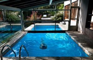 una piscina de agua azul en una casa en Aldebaran Hotel & Spa en San Carlos de Bariloche