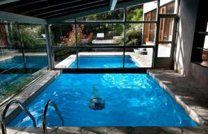 a swimming pool with blue water in a house at Aldebaran Hotel & Spa in San Carlos de Bariloche
