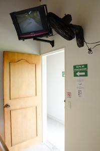 un televisor en la pared sobre una puerta en Hospedaje la Glorieta, en Santa Fe de Antioquia