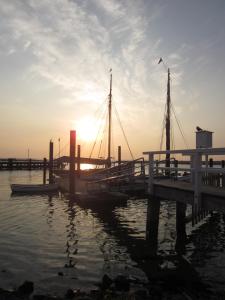 a dock with boats in the water at sunset at Ferienwohnung Marina Wendtorf in Wendtorf