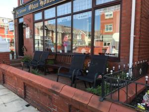 a bench in front of a building with windows at Oban House in Blackpool