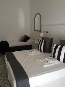 a hotel room with two beds and a mirror at Chiaia House in Naples
