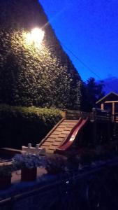 un parque infantil con un tobogán rojo por la noche en U Pastorku, en Račice