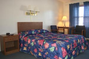 ein Hotelzimmer mit einem Bett mit einer bunten Decke in der Unterkunft Bluffs Inn in Bessemer