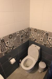 a bathroom with a toilet with black and white tiles at Angels Home in Platanitis Rodopis