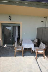 une terrasse avec une table et deux chaises dans une maison dans l'établissement Angels Home, à Platanitis