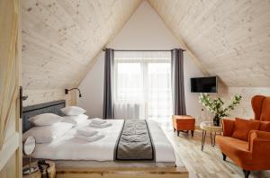 um quarto com uma cama grande e uma cadeira em Tatra Wood House em Zakopane