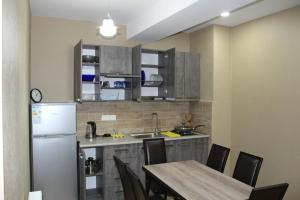 a kitchen with a table and a refrigerator at Bakuriani Residence 165 in Bakuriani