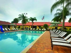 einen großen Pool mit Liegestühlen und einer amerikanischen Flagge in der Unterkunft Orlando RV Resort in Orlando