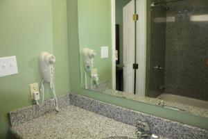a bathroom sink with a hair dryer and a mirror at Deluxe Inn Fort Stockton in Fort Stockton