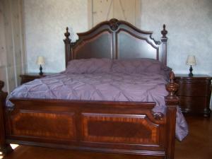 a large wooden bed in a bedroom with two lamps at Breezy Hills Cottages - Moonlight Cottage in Fredericksburg +15 photos