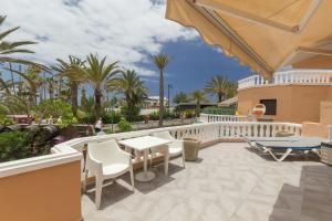 a balcony with a table and chairs and palm trees at TRG Studio in Arona