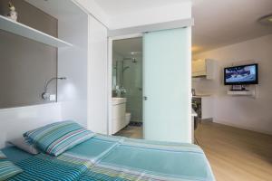 a bedroom with a blue bed and a bathroom at TRG Studio in Arona