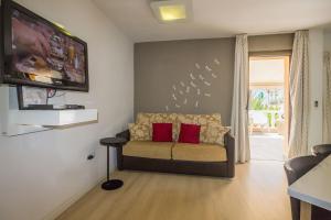 a living room with a couch with two red pillows at TRG Studio in Arona
