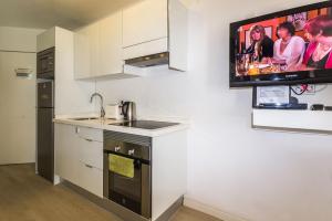 a kitchen with a tv hanging on the wall at TRG Studio in Arona