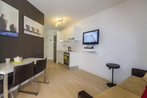 a living room with a couch and a table with a tv at TRG Studio in Arona +6 photos
