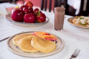 a table with plates of pancakes and a bowl of fruit at Hotel Turquesa Maya in Felipe Carrillo Puerto